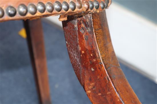 A George III mahogany hide-covered wing chair